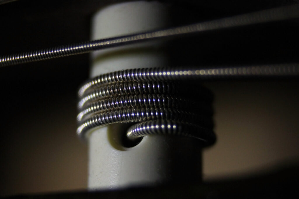 Extreme close-up of a guitar peg with a guitar string passing through it and wrapped around it