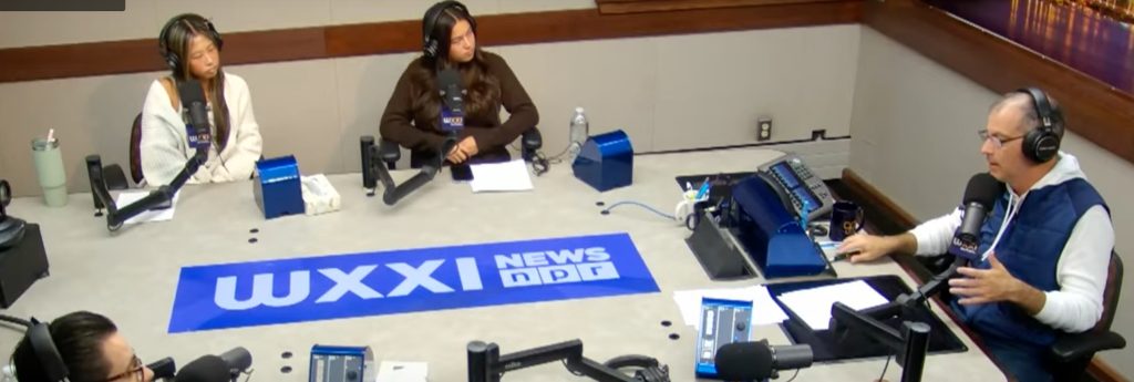 Four people seated around a table for a podcast conversation.